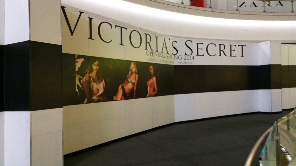 White barricde with 3 models in bras on black stripe in the middle for Victoria's Secret.