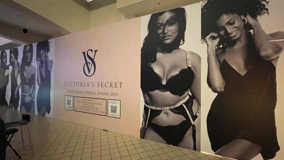 Barricade wrap with black and white images of models in lingerie with Pink middle area and Victoria's Secret coming soon text.