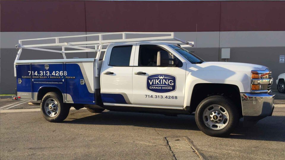 White Chevy work truck partial wrap with Blue Color and Viking Garage Door Logos