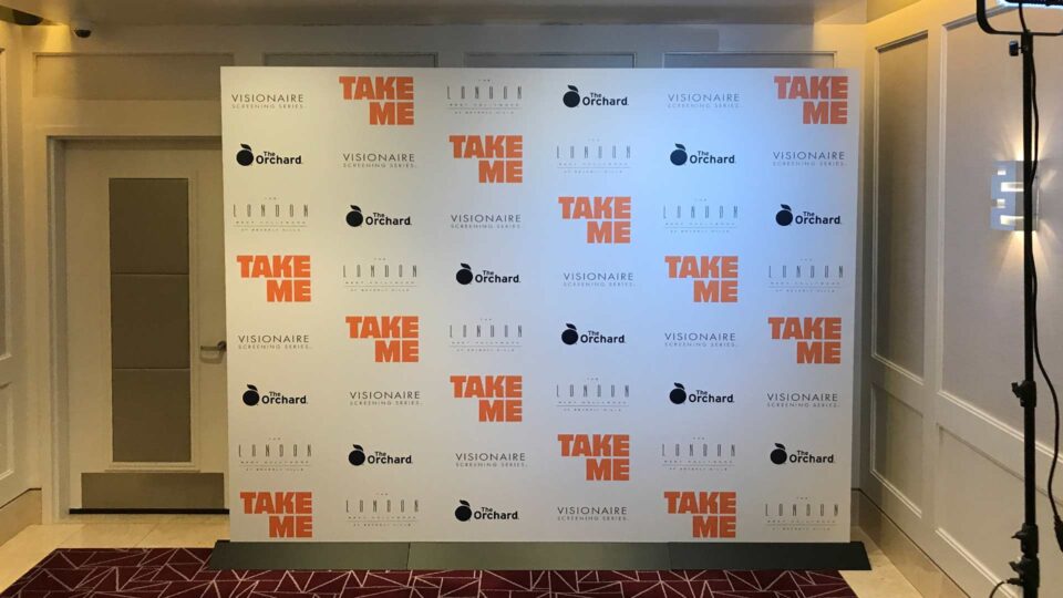 white medai wall with black and orange sponsor logos in room