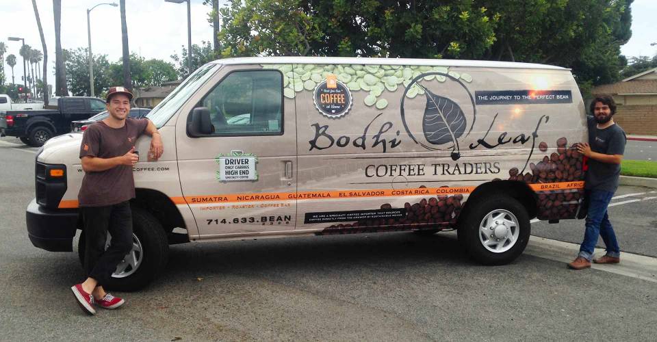 Owners of Bodhi Coffee posing next to their vinyl wrapped delivery van
