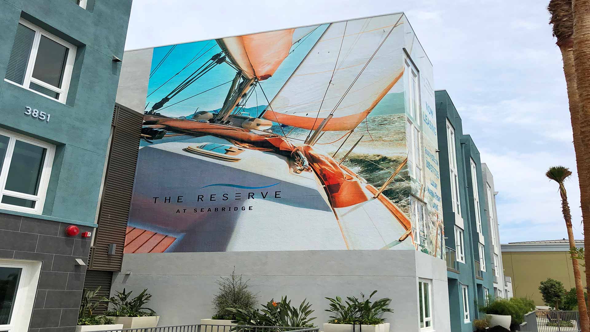 Large colorfull exterior wall graphic of sailboat on the water for Reserve Apartments