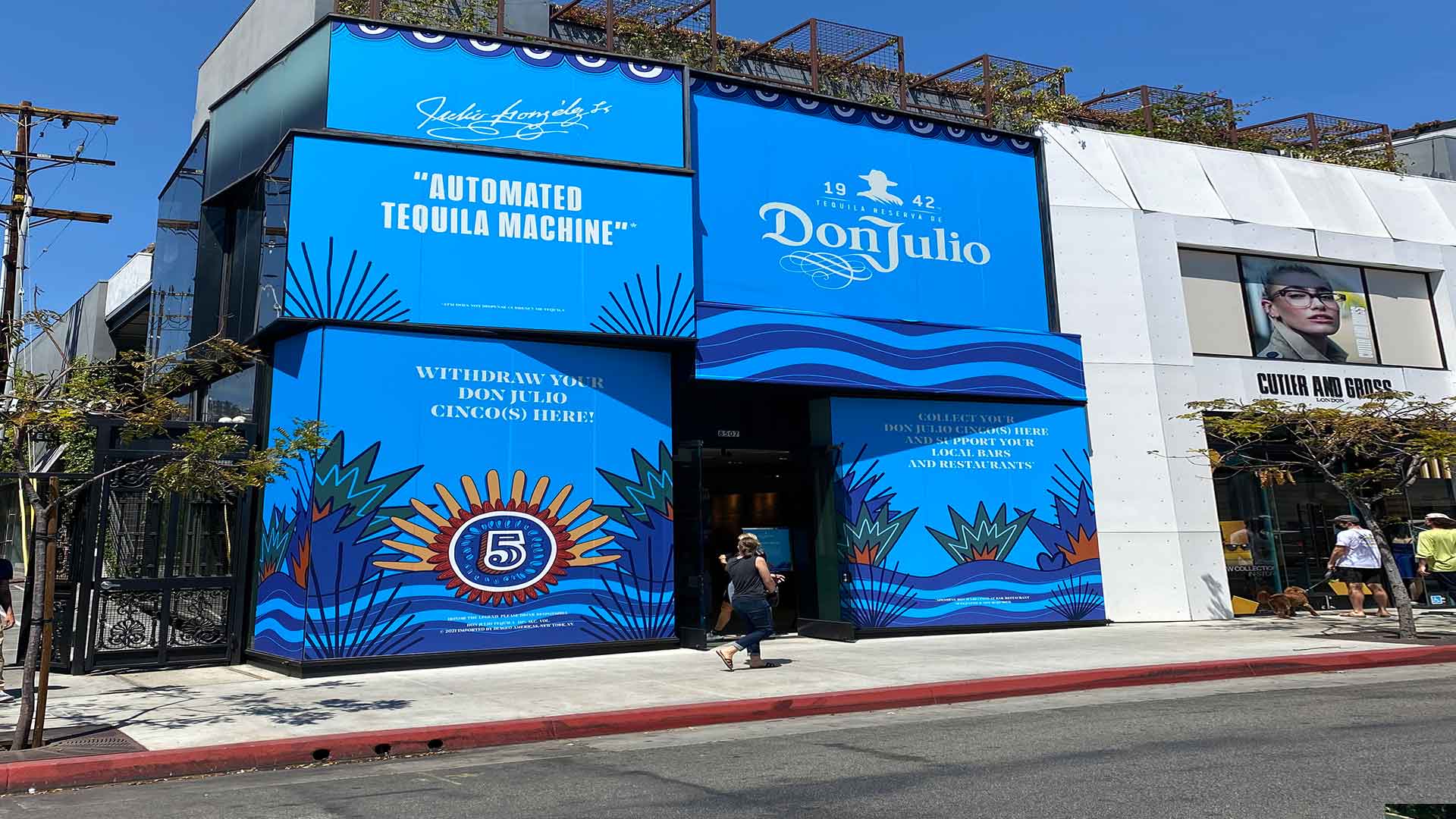 Multi story window graphics for Don Julio Tequila with blue background, white text and hispanic themed artwork