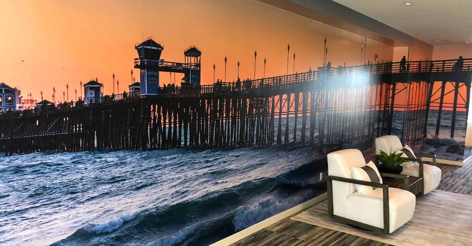 Lobby wall graphic showing a pier on the beach