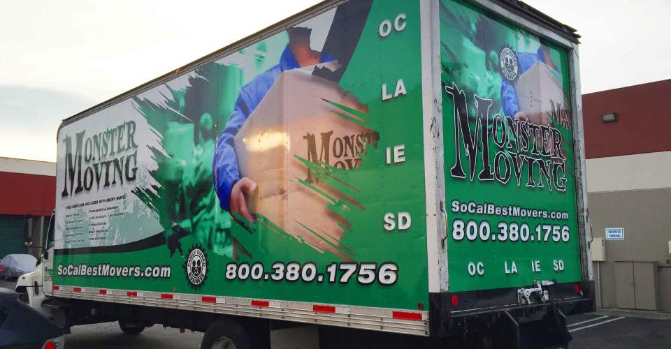 Moving truck with trailer vehicle wrap in green, white and black. Features man in blue uniforms moving boxes. text of logo and services
