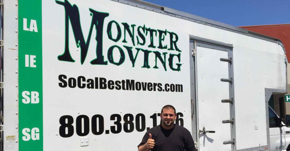 Customer with thumbs up in front of green, white and black trailer graphics
