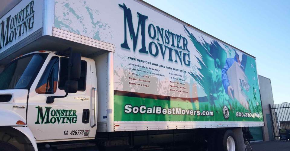 Moving truck with trailer vehicle wrap in green, white and black. Features man in blue uniforms moving boxes. text of logo and services