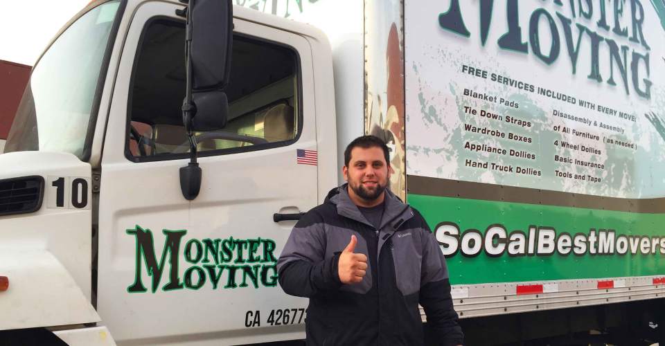 Customer with thumbs up in front of green, white and black trailer graphics