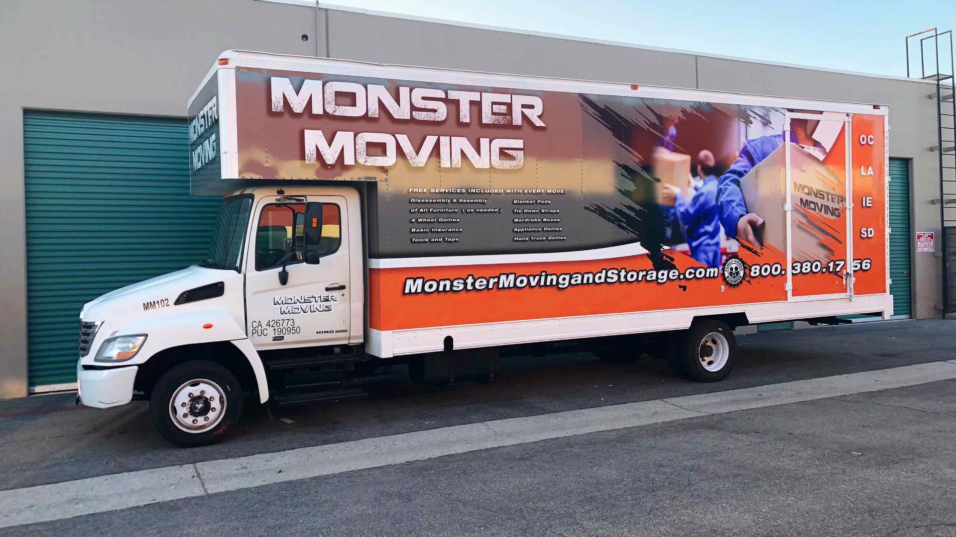Moving truck with trailer vehicle wrap in gray, white and orange. Features men in blue uniforms moving boxes. White text of logo and services
