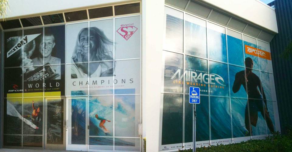 2 story vinyl perforated window graphics at Rip Curl Surf Corporate office featuring surfers and 2 models