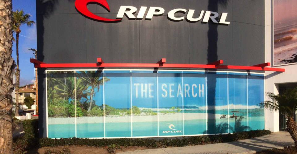 Perforated round Rip Curl Window Graphic of white sand tropical beach with boat and blue waves