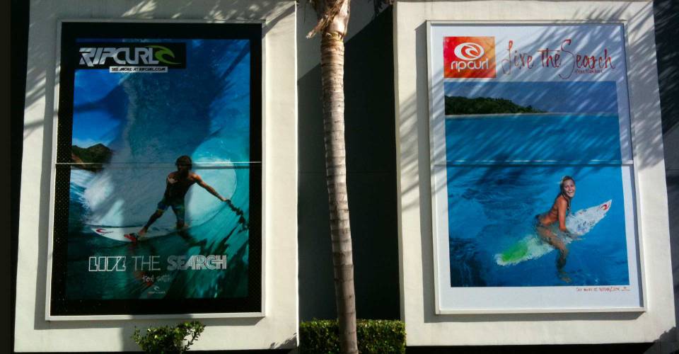 2 solid Rip Curl window graphics with guy in surfing and girl on surfboard sitting in blue ocean