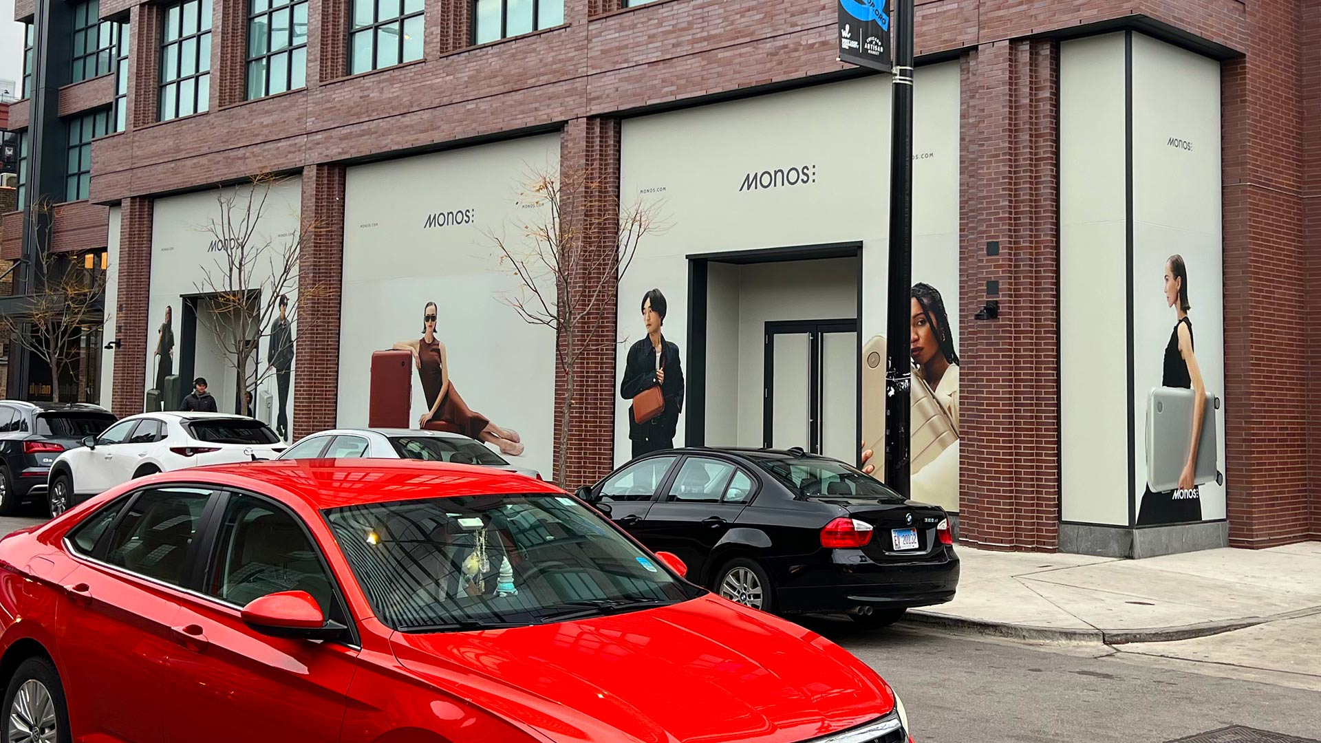 White window graphics featuring images of models with Monos luggage for Monos retail store in Chicago